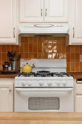 a white stove in a kitchen with a tea kettle on it at Central Location Cozy Home Villa in San Diego