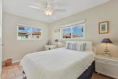 a bedroom with a white bed and two windows at Beach Getaway Apt - Walk to Sand & Bay in San Diego
