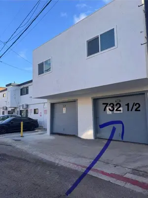 a building with a garage with a number on it at Beach Getaway Apt - Walk to Sand & Bay in San Diego