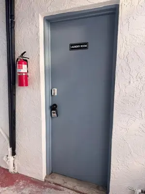 a blue door with a sign on it next to a fire extinguisher at Beach Getaway Apt - Walk to Sand & Bay in San Diego