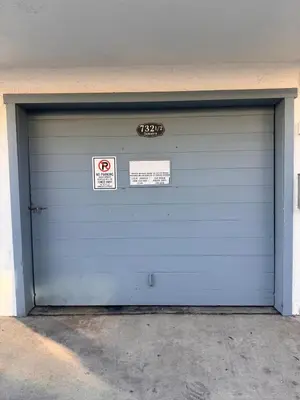 a blue garage door with two signs on it at Beach Getaway Apt - Walk to Sand & Bay in San Diego
