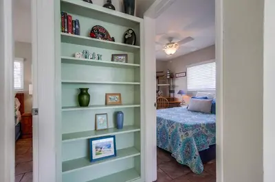 a room with bookshelves and a bedroom with a bed at Beach Getaway Apt - Walk to Sand & Bay in San Diego