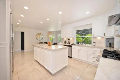 a large kitchen with white cabinets and a large island at Casa Fuerte - Valley Estate w Pool Hot Tub Sports Court in Temecula
