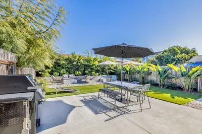 a patio with a table and chairs and an umbrella at Carlsbad Bungalow Large Backyard in Carlsbad