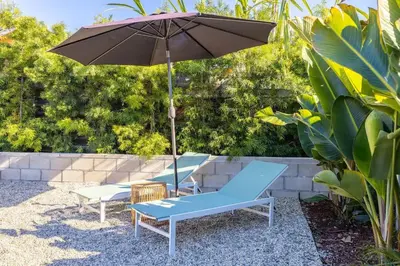 a patio with two chairs and an umbrella at Carlsbad Bungalow Large Backyard in Carlsbad