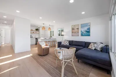 a living room with a blue couch and a table at Carlsbad Bungalow Large Backyard in Carlsbad