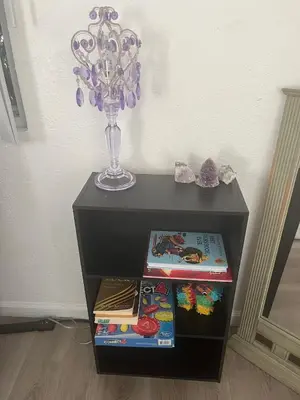 a black table with a vase and books on it at Redwing in San Marcos
