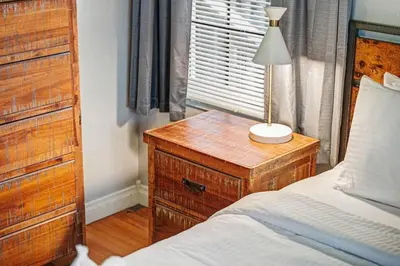 a bedroom with a bed and a table with a lamp on it at Charming La Mesa Cottage - Patio - Quiet Neighborhood - Family in La Mesa
