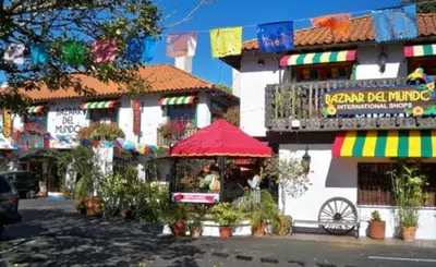 a building with a red umbrella in front of it at Charming La Mesa Cottage - Patio - Quiet Neighborhood - Family in La Mesa