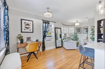 a living room with a table and chairs and a kitchen at The Downtown Carraige Flat in San Diego