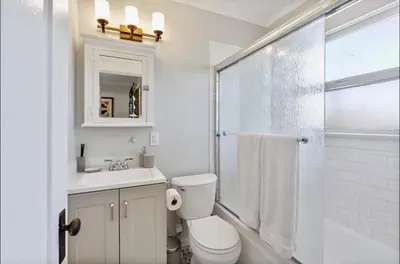 a white bathroom with a toilet and a sink at The Downtown Carraige Flat in San Diego