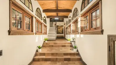 a hallway with wooden ceilings and stairs with potted plants at Villa Di Gioia by AvantStay Private Wine-Country Estate Vineyard Views • Near Top Temecula Wineries in Temecula