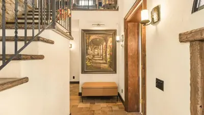 a hallway with stairs and a painting on the wall at Villa Di Gioia by AvantStay Private Wine-Country Estate Vineyard Views • Near Top Temecula Wineries in Temecula