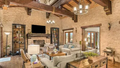 a large living room with a stone wall at Villa Di Gioia by AvantStay Private Wine-Country Estate Vineyard Views • Near Top Temecula Wineries in Temecula