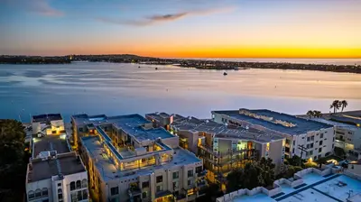 an aerial view of a city and the ocean at sunset at Sunset on Sail Bay - Beautiful 2 Bedroom Condo in San Diego
