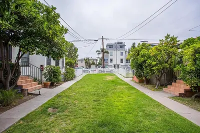 a yard with a white fence and green grass at Cozy 1bed Home near Down Town SD in San Diego