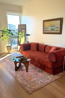 a living room with a red couch and a coffee table at Luxury Designer Hillcrest Apartment with Pool & Gym in San Diego