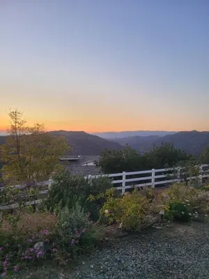 a white fence on a hill with a sunset in the background at Beverlys Hilltop Retreat in Fallbrook