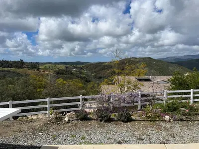 a white fence with a view of the mountains at Beverlys Hilltop Retreat in Fallbrook
