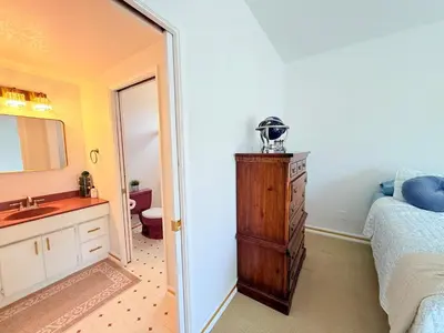 a bathroom with a bed and a sink and a mirror at 6BR5BA Hot Tub Steps to Beach Parking Pet Friendly in San Diego
