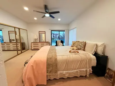 a bedroom with a bed with a ceiling fan at 6BR5BA Hot Tub Steps to Beach Parking Pet Friendly in San Diego