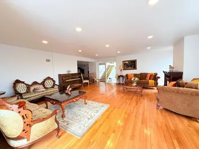 a large living room with wooden floors and couches at 6BR5BA Hot Tub Steps to Beach Parking Pet Friendly in San Diego