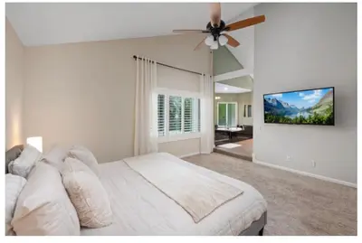 a bedroom with a white bed and a ceiling fan at Dream vacation home in Laguna Hills