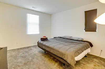 a bedroom with a bed and two windows at Family Getaway with Pool, 8 Mi to Lake Elsinore! in Wildomar