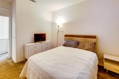 a bedroom with a white bed and a television at Family Getaway with Pool, 8 Mi to Lake Elsinore! in Wildomar