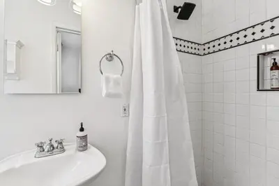 a bathroom with a white shower curtain and a sink at Oceanfront St Anns Beach Laguna Beach Private Beach Stairs To The Sand in Laguna Beach