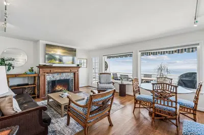 a living room with a fireplace and a table and chairs at Oceanfront St Anns Beach Laguna Beach Private Beach Stairs To The Sand in Laguna Beach