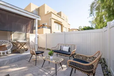 a patio with chairs and a table and a fence at Boho Chic Cottage Walk to Cafes Outdoor Lounge in San Diego