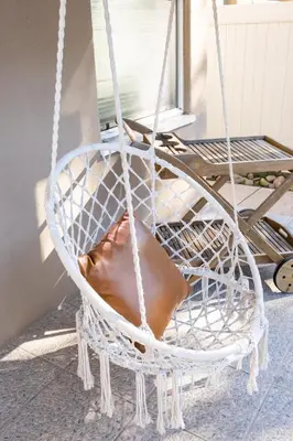 a white swing chair sitting on a porch at Boho Chic Cottage Walk to Cafes Outdoor Lounge in San Diego