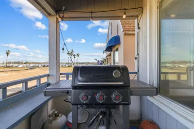 a grill on a balcony with a view of an airport at Remodeled 4BR Bayfront Home | Sleeps 12 | Stunning Views + BBQ Patio in San Diego