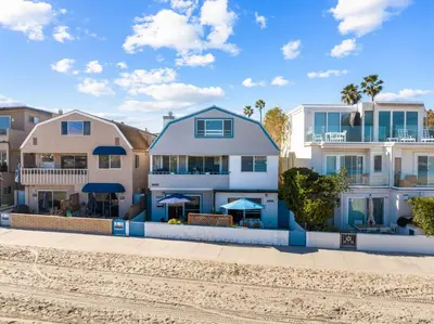 a house on the beach with buildings at Cozy 2BR Bayfront Home | Patio + Water Views in Mission Beach in San Diego