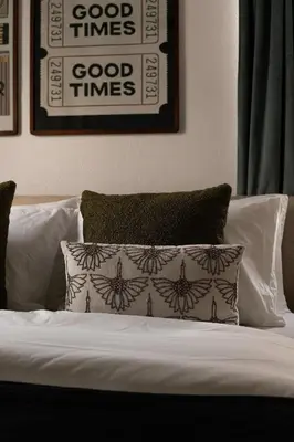 a bed with a pillow and a picture on the wall at Walk to Balboa and Zoo Central Renovated Villa in San Diego