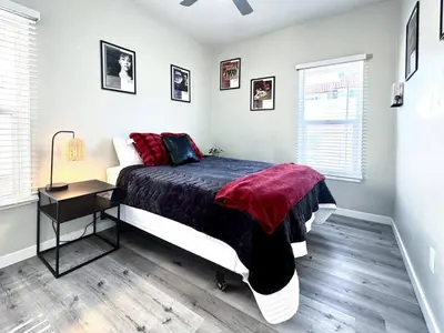 a bedroom with a bed and a night stand and a window at A Walkable Music-Themed Escape Near Downtown in San Diego
