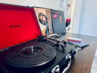 a table with a record player and dvds at A Walkable Music-Themed Escape Near Downtown in San Diego