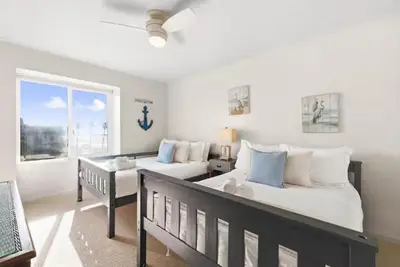 a bedroom with two beds and a table and a window at Beachfront Resort-sunset views deck & luxe king in Oceanside