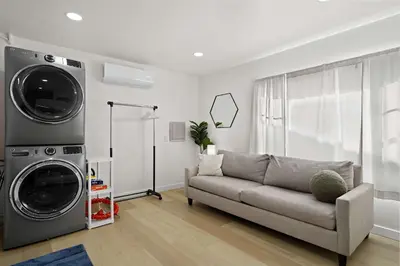 a living room with a couch and a washing machine at Stylish Retreat Near Mission Bay with Games & Firepit in San Diego