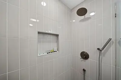a white bathroom with a shower and a mirror at Stylish Retreat Near Mission Bay with Games & Firepit in San Diego