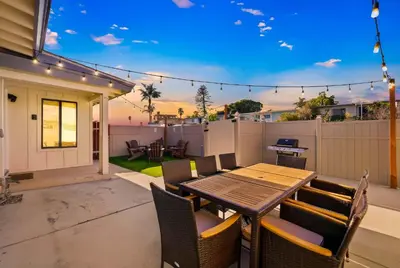 a patio with a table and chairs and a fence at Stylish Retreat Near Mission Bay with Games & Firepit in San Diego