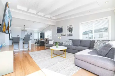 a living room with a couch and a table at 3Br Oceanfront Home W Balcony Right Over The Sand By Beachview Rentals in Newport Beach