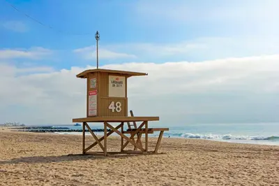 a lifeguard stand on a beach with the ocean at 3Br Oceanfront Home W Balcony Right Over The Sand By Beachview Rentals in Newport Beach