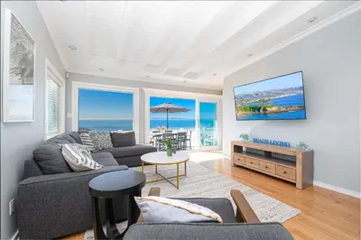 a living room with a view of the ocean at 3Br Oceanfront Home W Balcony Right Over The Sand By Beachview Rentals in Newport Beach