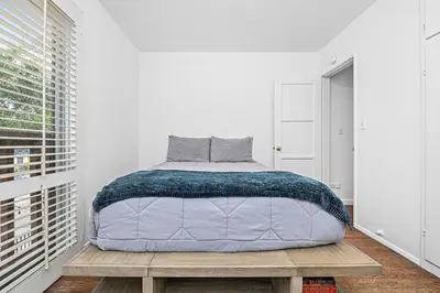 a bedroom with a large bed on a wooden platform at 4Br Home, One House From Balboa Beach W Rooftop Deck By Beachview Rentals in Newport Beach