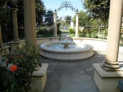 a fountain in a courtyard with pillars and flowers at Exclusive Top Floor 1 bedroom in central Irvine one month min in Irvine