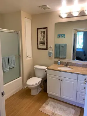 a bathroom with a toilet and a sink and a mirror at Exclusive Top Floor 1 bedroom in central Irvine one month min in Irvine