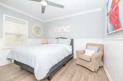 a bedroom with a bed and a chair in it at 3Br Oceanfront Home W Patio Right On The Sand By Beachview Rentals in Newport Beach