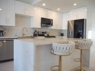 a kitchen with white cabinets and gold bar stools at Luxury 3BR, 2BA Newly Renovated with Huge Backyard in San Diego